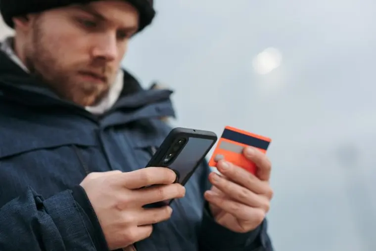 man purchasing crypto on phone man using card on phone to purchase